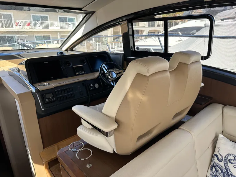 Slide: The Image of Das Cockpit einer Sea Ray Sundancer 400 von 2017 mit beigen Ledersitzen und einem modernen Steuerstand. - 27