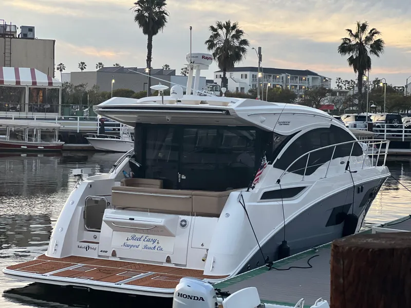 Slide: The Image of Eine Sea Ray Sundancer 400 von 2017 liegt an einem Dock. Palmen und Gebäude im Hintergrund. - 18