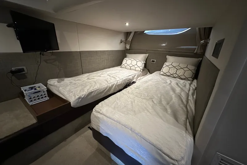 Slide: The Image of 2017 Sea Ray Sundancer 400 cabin with twin beds, modern decor, and a wall-mounted TV. - 42