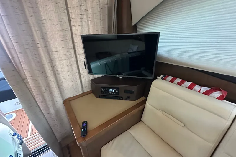 Slide: The Image of Interior of 2017 Sea Ray Sundancer 400 with TV, remote, and seating area. - 54