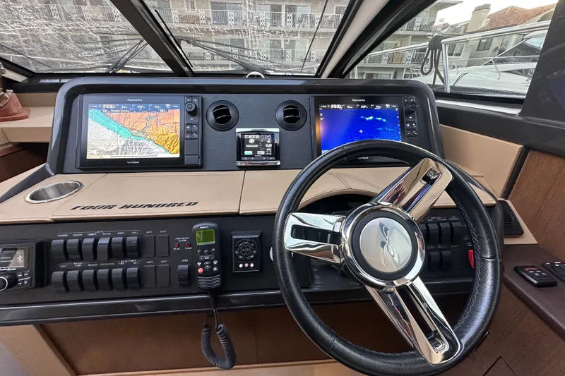 Slide: The Image of Cockpit of 2017 Sea Ray Sundancer 400 with navigation screens and steering wheel. - 43