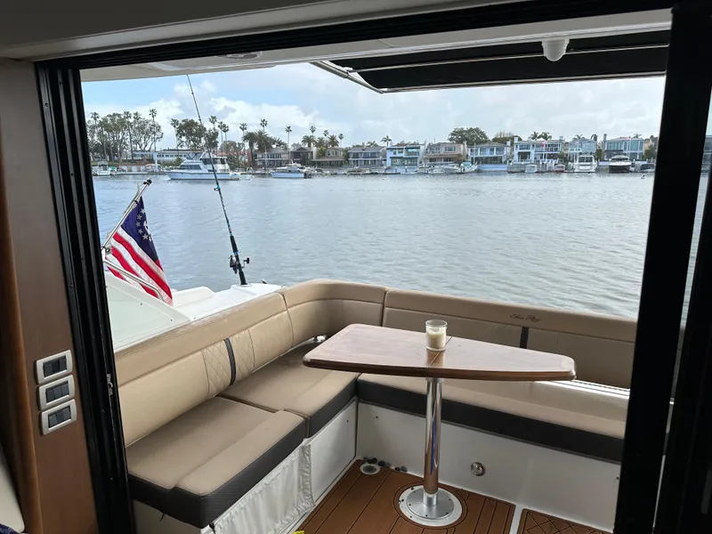Slide: The Image of Die Sea Ray Sundancer 400 von 2017 zeigt eine gemütliche Sitzecke mit Tisch und Blick auf das Wasser. - 34
