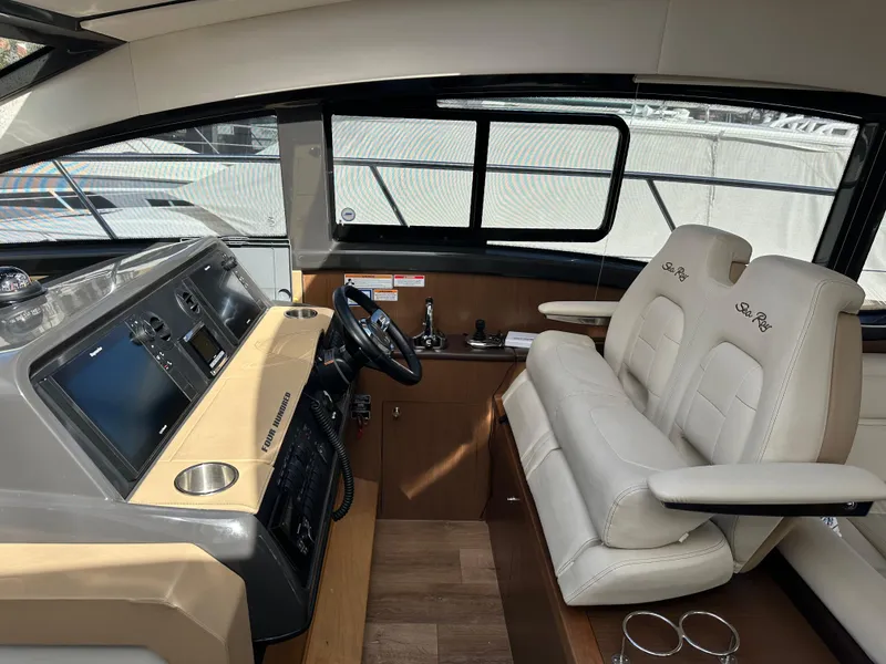 Slide: The Image of Das Bild zeigt das Cockpit einer Sea Ray Sundancer 400 von 2017 mit zwei beigen Ledersitzen. - 39