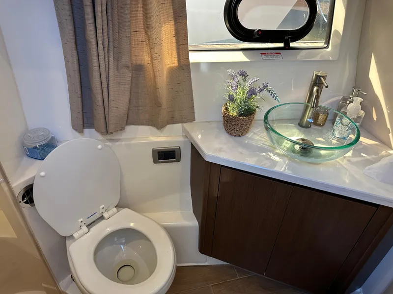 Slide: The Image of Das Bild zeigt ein modernes Badezimmer auf einem Boot mit einer Toilette und einem Glaswaschbecken. - 32