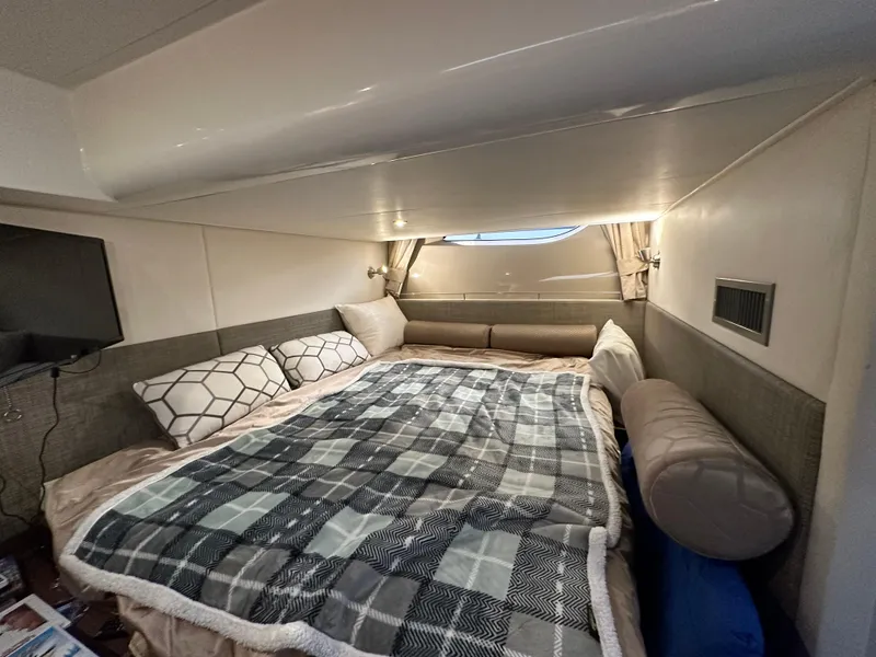 Slide: The Image of Die Kabine der Sea Ray Sundancer 400 von 2017 zeigt ein gemütliches Bett mit kariertem Bettzeug. - 25