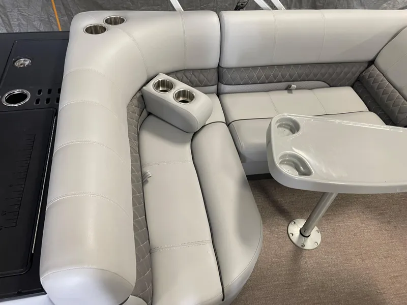 Slide: The Image of 2020 Ranger 220FC boat interior with gray seating, cup holders, and a small table. - 12