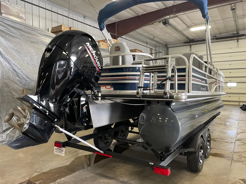 Slide: The Image of 2020 Ranger 220FC pontoon boat with Mercury outboard motor in a garage setting. - 2