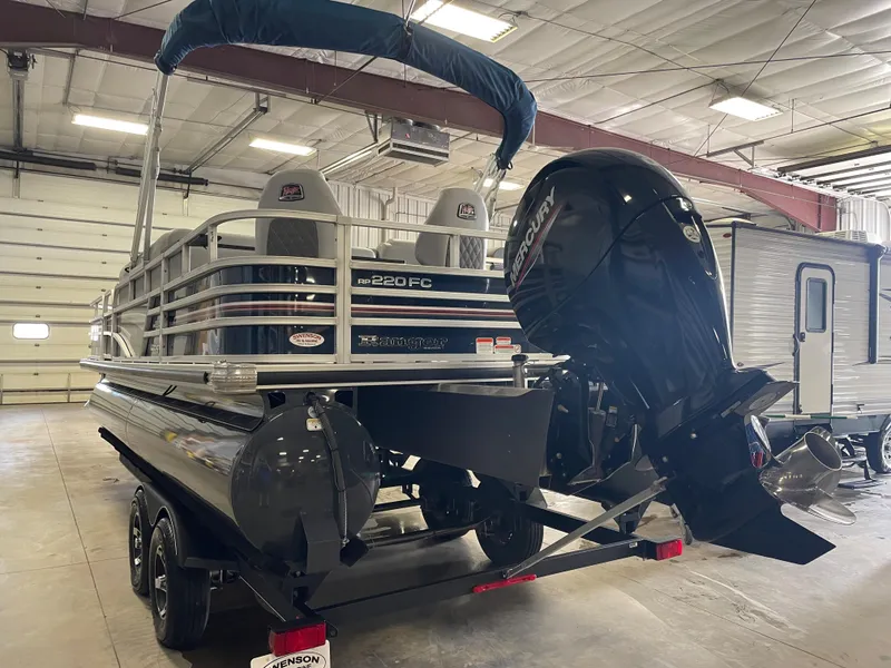 Slide: The Image of 2020 Ranger 220FC pontoon boat in indoor storage, featuring a powerful outboard motor. - 3