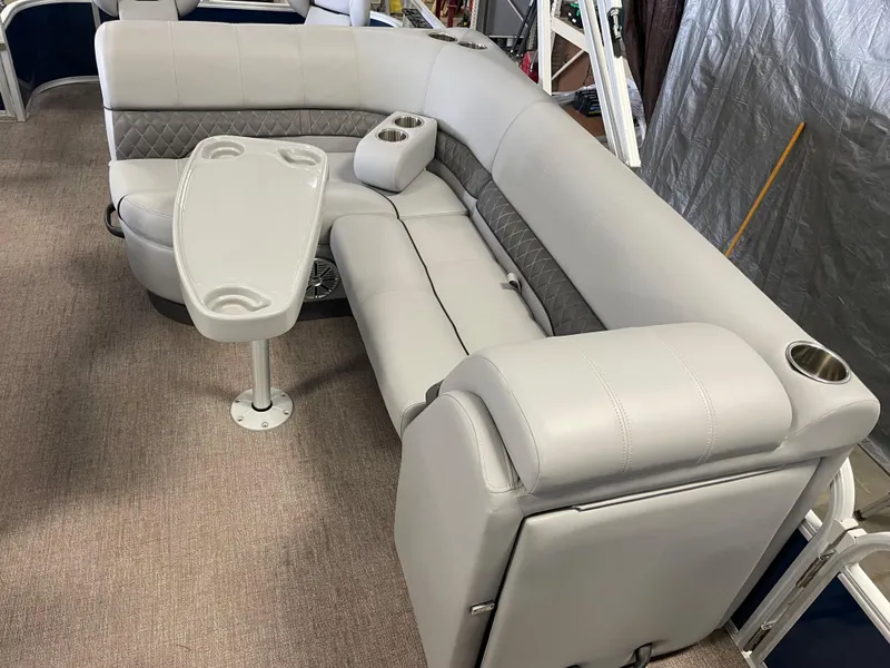 Slide: The Image of 2020 Ranger 220FC boat interior with gray seating and table, featuring cup holders. - 4