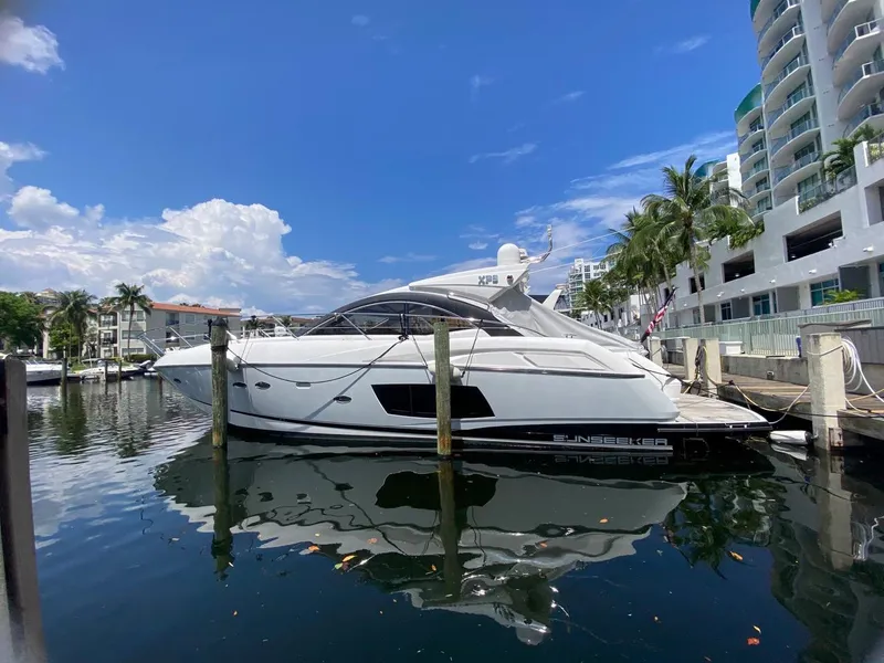 Slide: The Image of 2014 Sunseeker 48 Portofino XPS yacht docked in a marina, clear blue sky. - 2