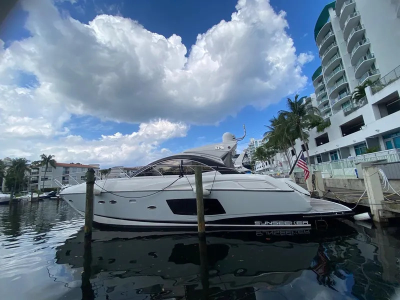 Slide: The Image of 2014 Sunseeker 48 Portofino XPS yacht docked at marina, under cloudy sky. - 3