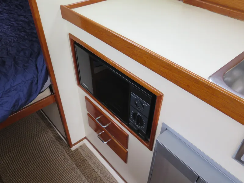 Slide: The Image of 1988 Blackman 26 Billfisher interior with microwave and wooden cabinetry. - 10