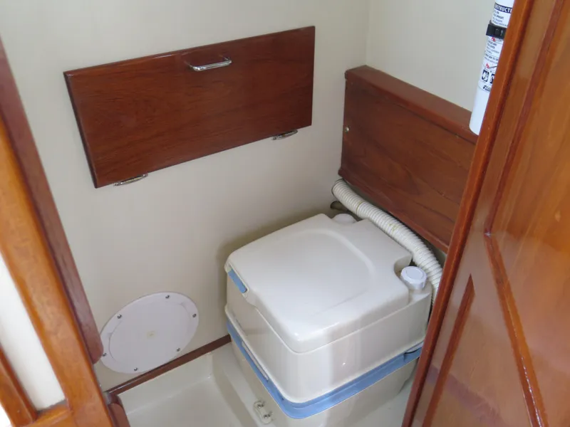 Slide: The Image of Compact marine toilet in 1988 Blackman 26 Billfisher boat, featuring wooden cabinetry. - 13