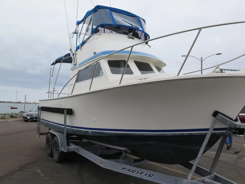 Slide: The Image of 1988 Blackman 26 Billfisher boat on trailer, featuring blue canopy and sleek design. - 33