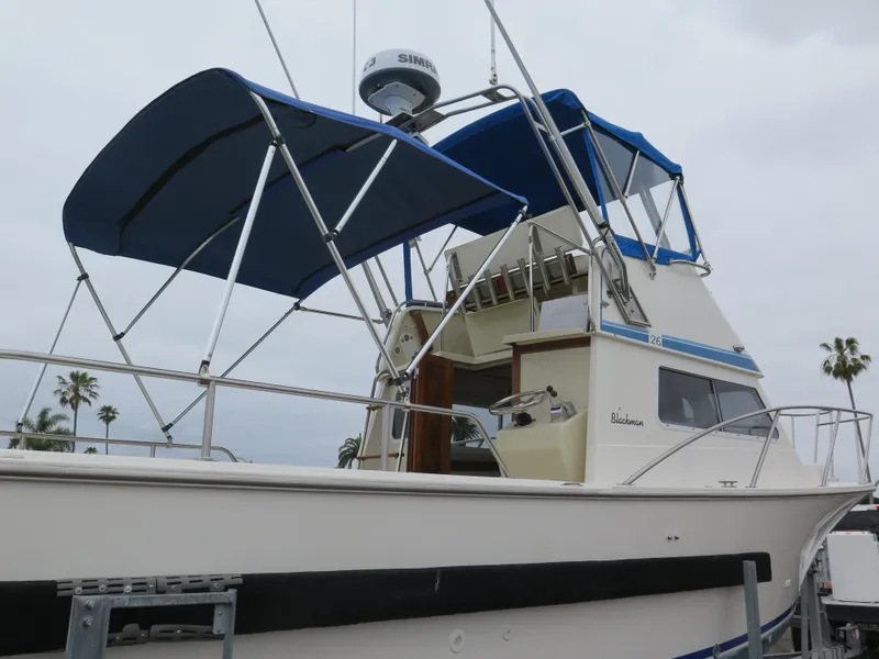 Slide: The Image of 1988 Blackman 26 Billfisher boat with blue canopy and radar, docked outdoors. - 36