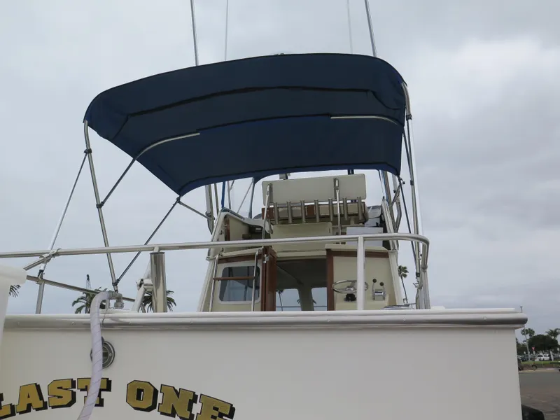 Slide: The Image of 1988 Blackman 26 Billfisher boat with blue canopy and visible helm. - 37