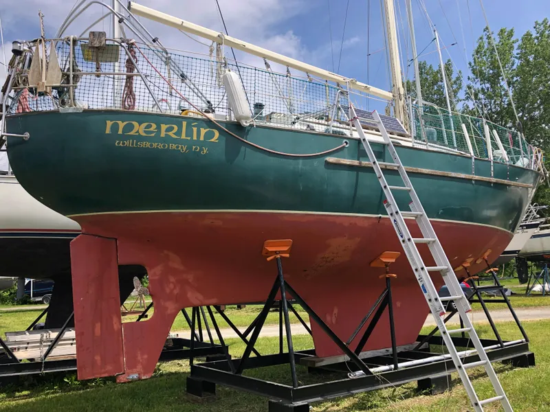 Slide: The Image of 1986 Pacific Seacraft Crealock 34 sailboat on stands, green hull, ladder beside. - 1