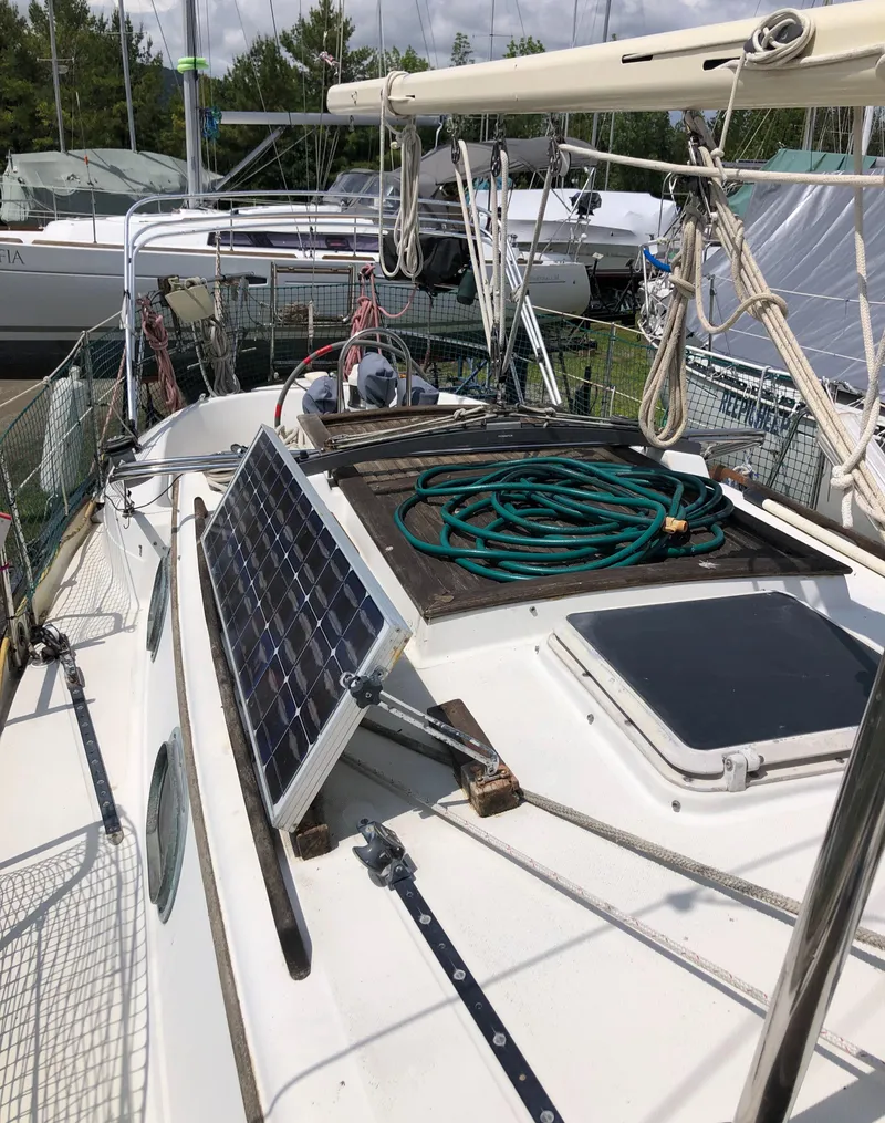 Slide: The Image of 1986 Pacific Seacraft Crealock 34 sailboat deck with solar panel and coiled hose. - 16
