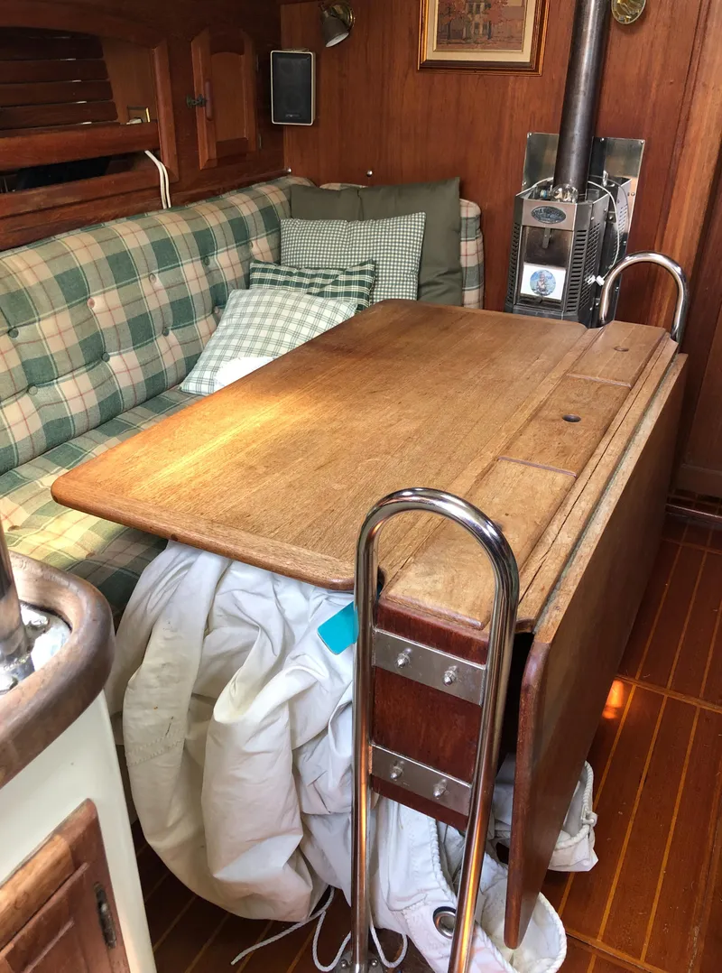 Slide: The Image of Interior of 1986 Pacific Seacraft Crealock 34 sailboat with wooden table and plaid seating. - 18