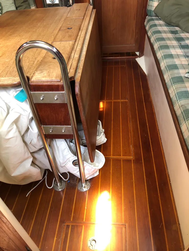 Slide: The Image of 1986 Pacific Seacraft Crealock 34 interior with wooden flooring and foldable table. - 19