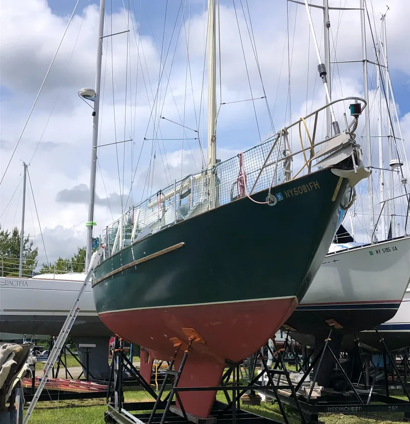 Slide: The Image of 1986 Pacific Seacraft Crealock 34 sailboat on dry dock, green hull, overcast sky. - 2