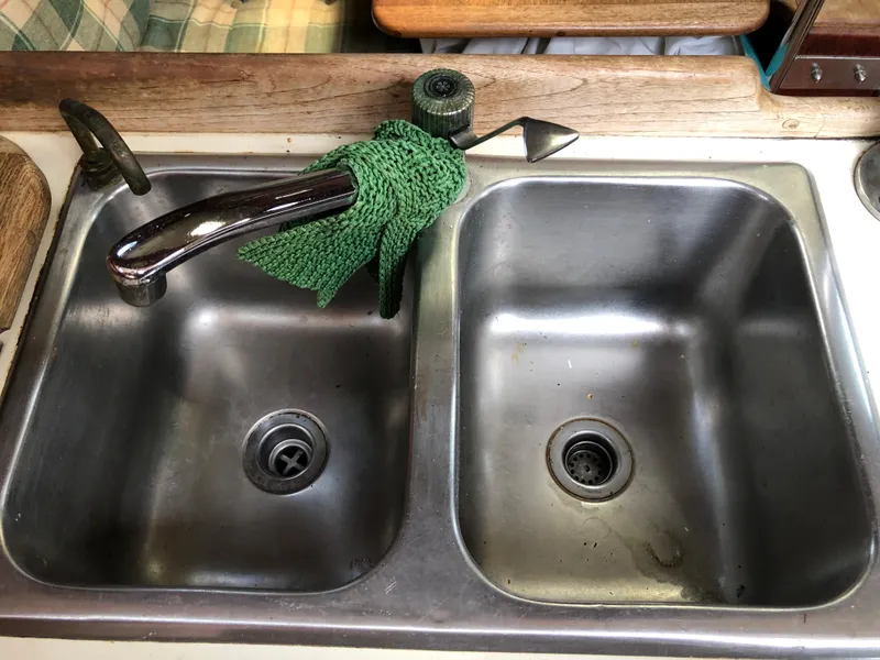 Slide: The Image of Double stainless steel sink on 1986 Pacific Seacraft Crealock 34 yacht with green cloth. - 25