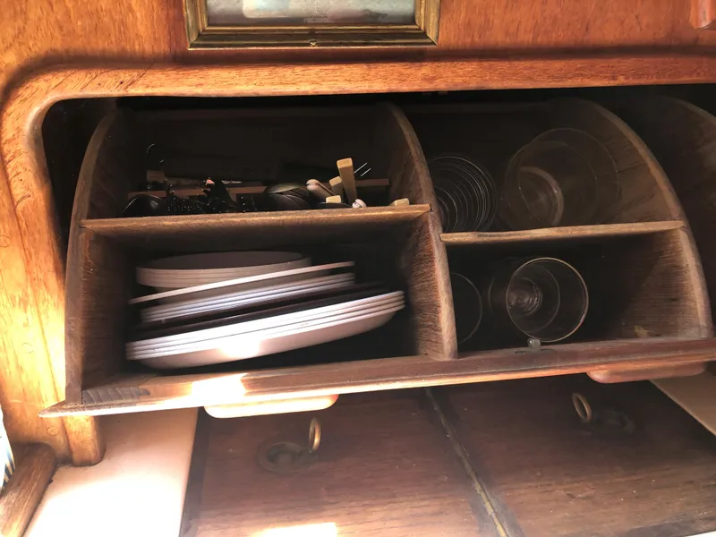 Slide: The Image of Wooden storage cabinet with plates and glasses on a 1986 Pacific Seacraft Crealock 34 sailboat. - 29