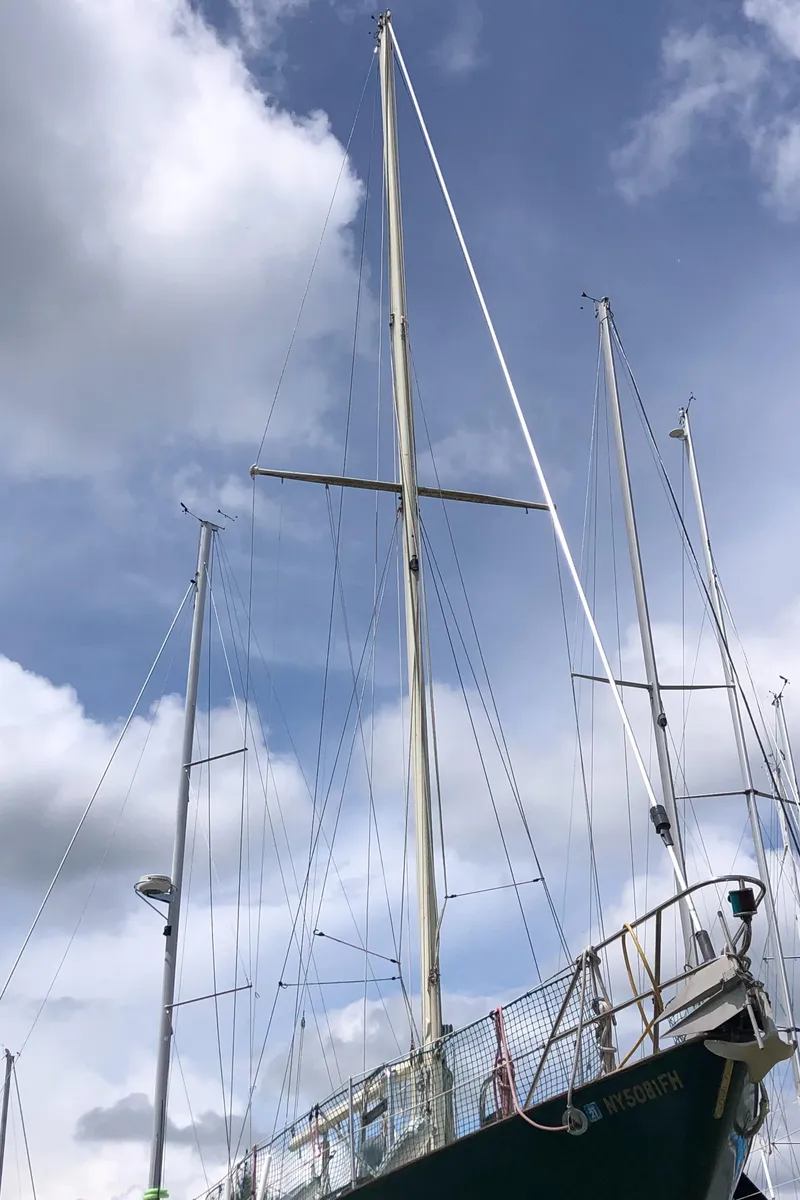 Slide: The Image of 1986 Pacific Seacraft Crealock 34 sailboat with tall mast against cloudy sky. - 3