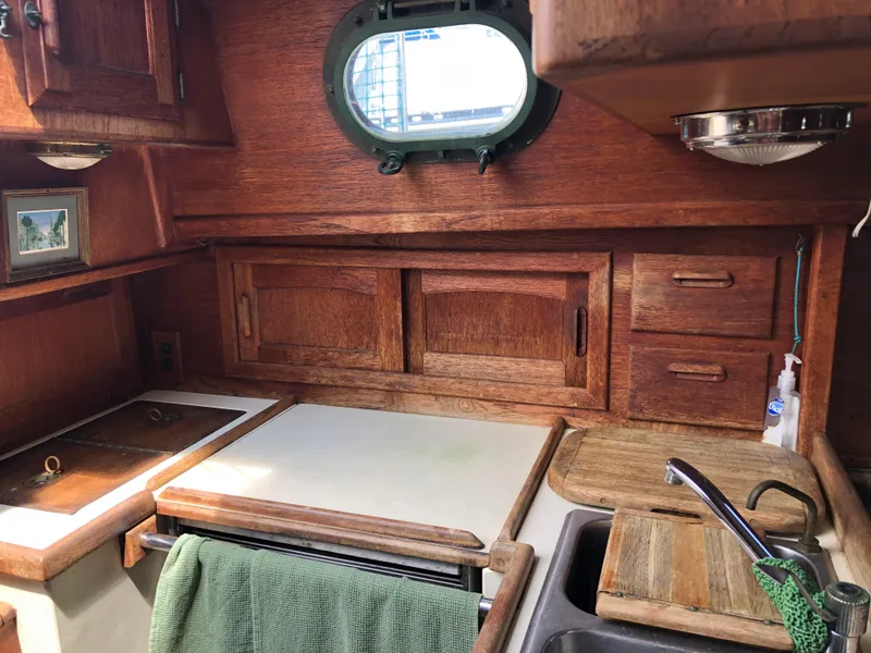 Slide: The Image of 1986 Pacific Seacraft Crealock 34 yacht interior with wooden cabinetry and porthole window. - 30