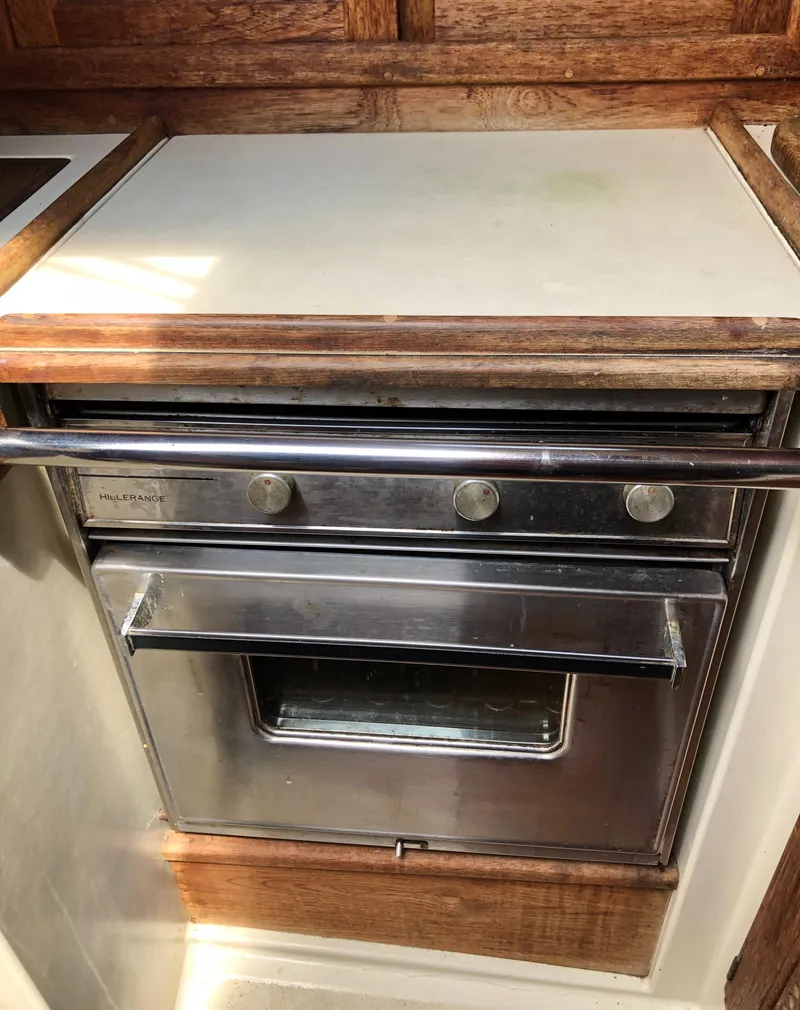 Slide: The Image of 1986 Pacific Seacraft Crealock 34 galley oven with wooden trim. - 31