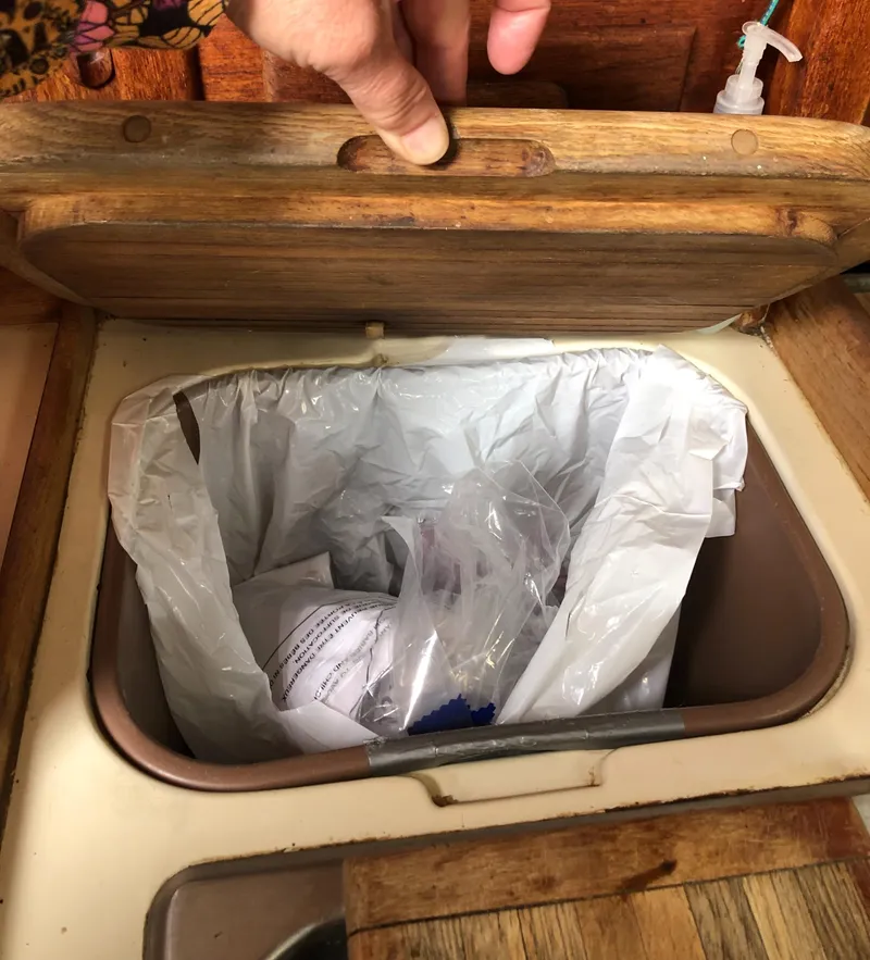 Slide: The Image of Wooden lid opening to reveal trash bin on 1986 Pacific Seacraft Crealock 34 yacht. - 34