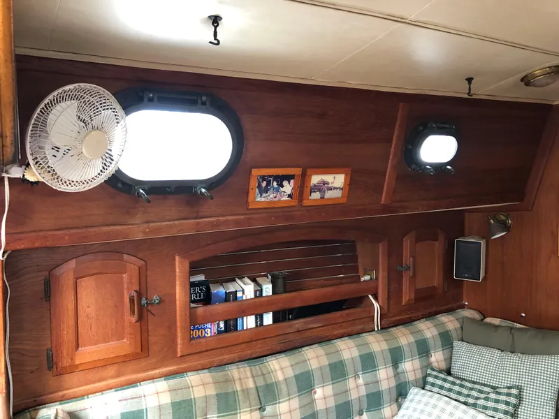 Slide: The Image of Interior of 1986 Pacific Seacraft Crealock 34 with wooden cabinets and plaid seating. - 35