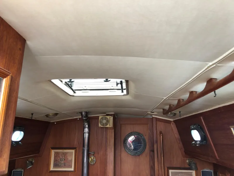 Slide: The Image of Interior of 1986 Pacific Seacraft Crealock 34 sailboat with wooden paneling and portholes. - 36