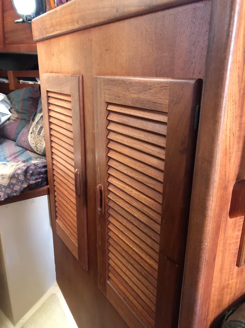 Slide: The Image of 1986 Pacific Seacraft Crealock 34 interior wooden cabinet with louvered doors. - 43