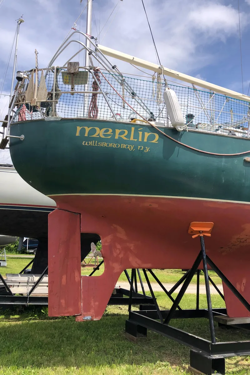 Slide: The Image of 1986 Pacific Seacraft Crealock 34 sailboat on stand, green hull, "Merlin" name visible. - 5