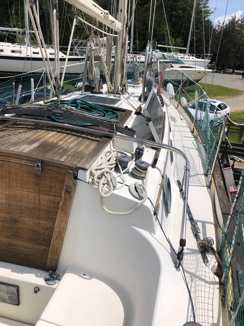 Slide: The Image of 1986 Pacific Seacraft Crealock 34 sailboat deck with rigging and wooden hatch. - 9