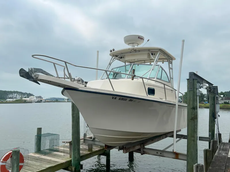 The Image of 2006 Parker 2310 Walkaround boat docked on a lift by the water. - 0