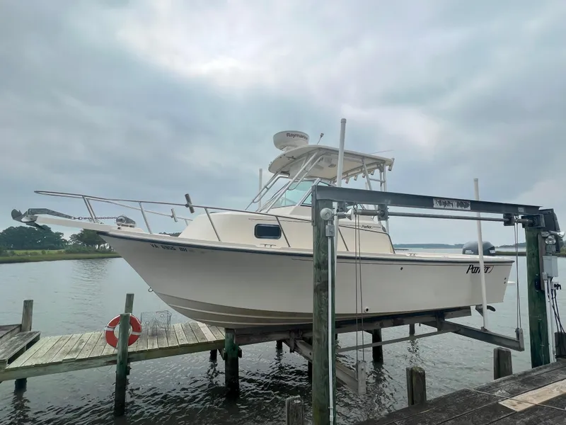 Slide: The Image of 2006 Parker 2310 Walkaround boat on lift by dock, overcast sky. - 3