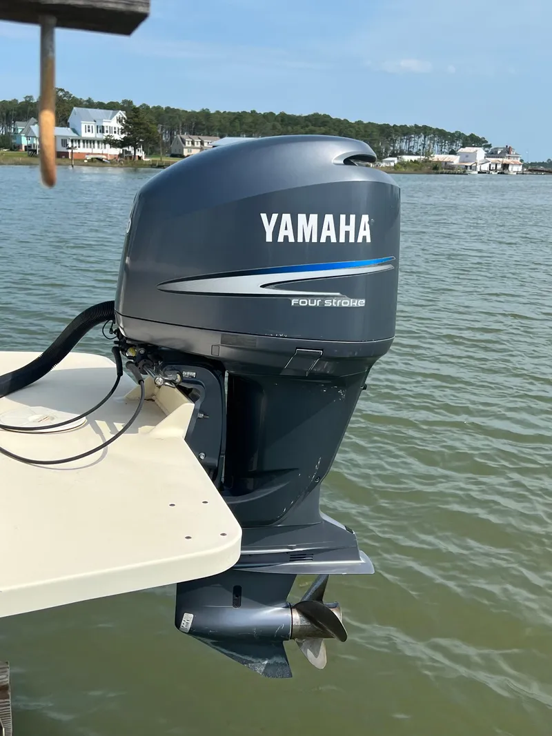 Slide: The Image of Yamaha four-stroke outboard motor on 2006 Parker 2310 Walkaround boat, near waterfront homes. - 6