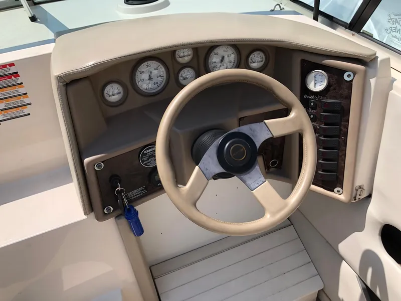 Slide: The Image of 1997 Ebbtide 2300 Cuddy boat dashboard with steering wheel and gauges. - 10