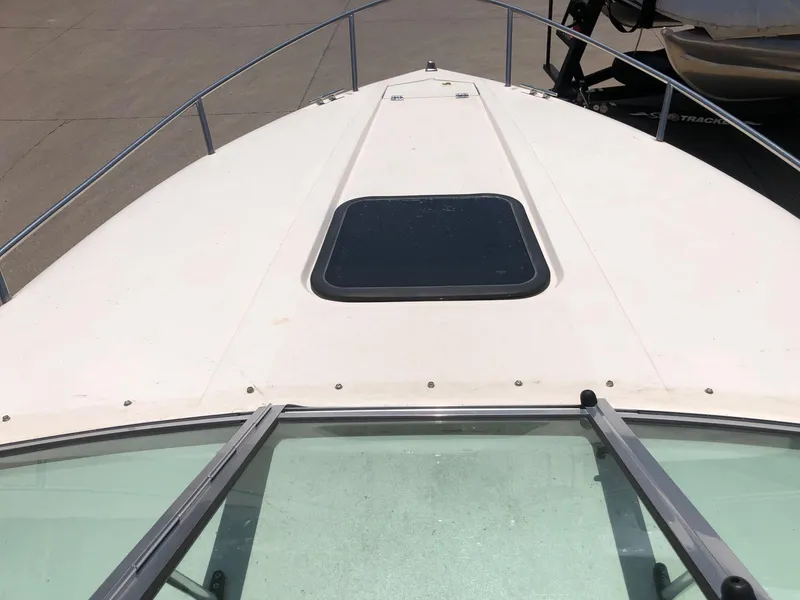 Slide: The Image of 1997 Ebbtide 2300 Cuddy boat deck with hatch, docked outdoors. - 18