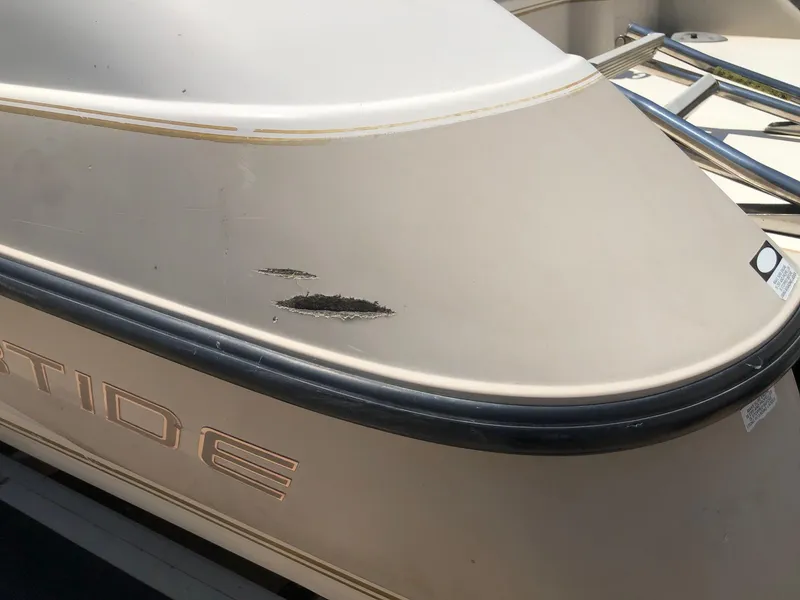 Slide: The Image of 1997 Ebbtide 2300 Cuddy boat with visible hull damage. - 21