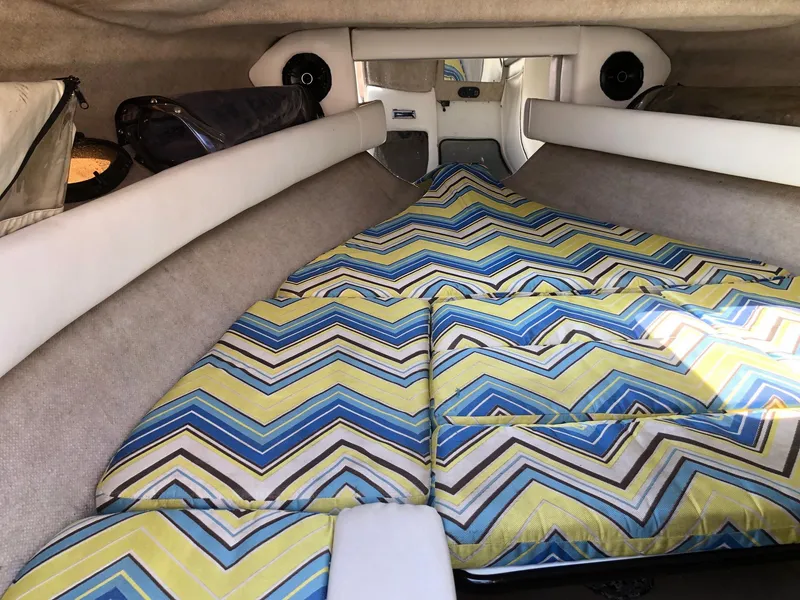 Slide: The Image of 1997 Ebbtide 2300 Cuddy cabin interior with colorful zigzag-patterned cushions. - 6