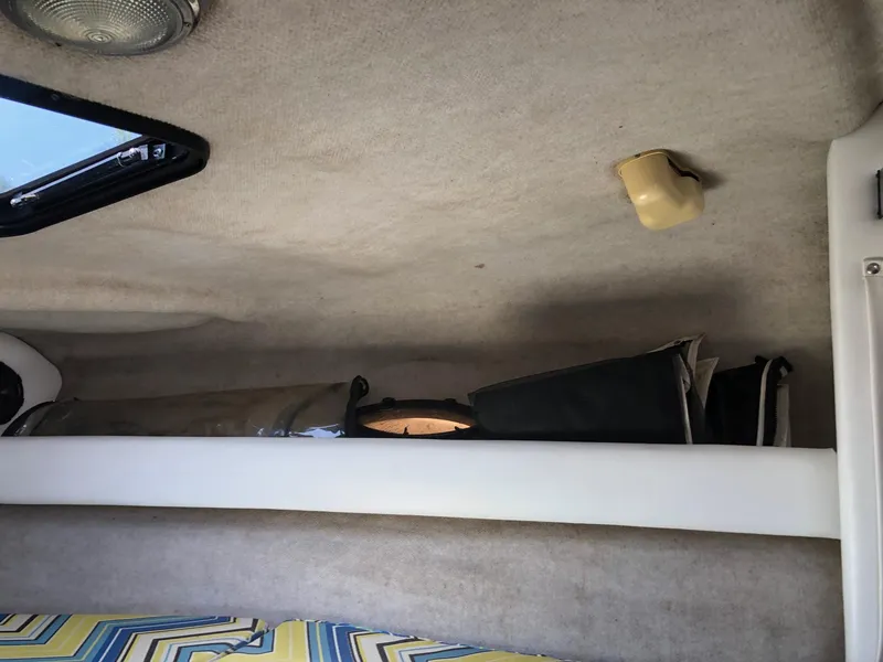 Slide: The Image of Interior of 1997 Ebbtide 2300 Cuddy cabin with storage shelf and patterned cushion. - 8