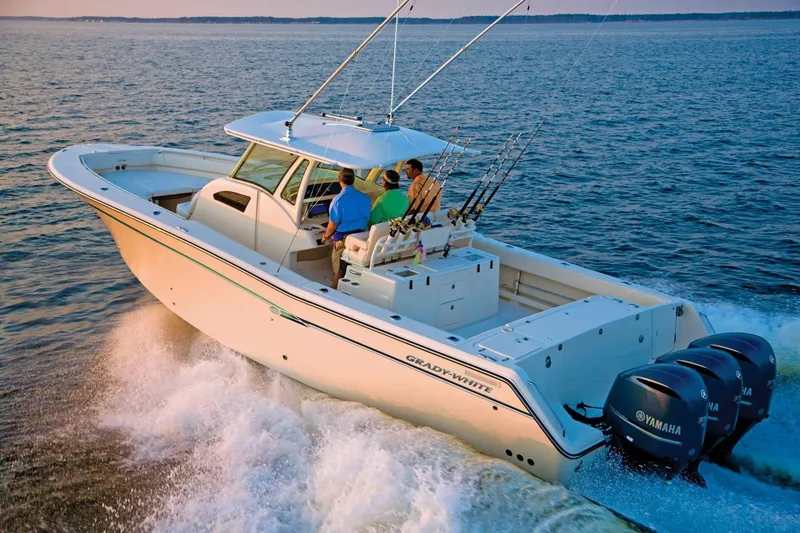 Slide: The Image of 2024 Grady-White Canyon 386 boat cruising on open water with fishing rods. - 1