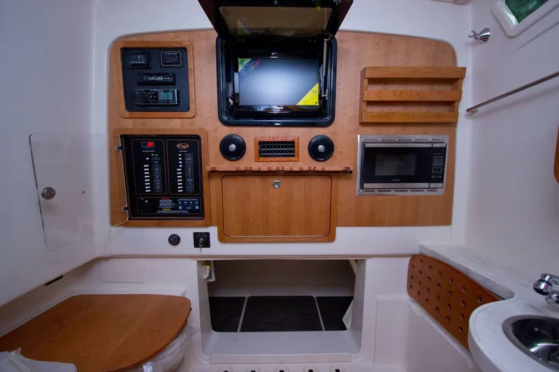 Slide: The Image of 2024 Grady-White Canyon 386 interior with control panel, microwave, and sink. - 16
