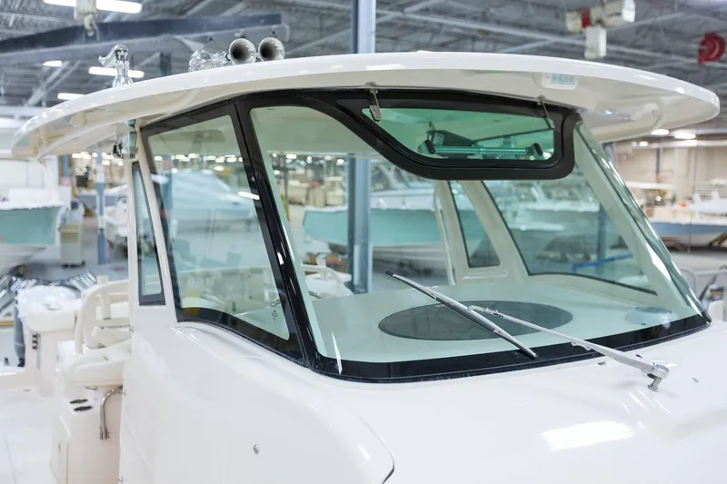 Slide: The Image of 2024 Grady-White Canyon 386 boat windshield and helm area in a showroom. - 4