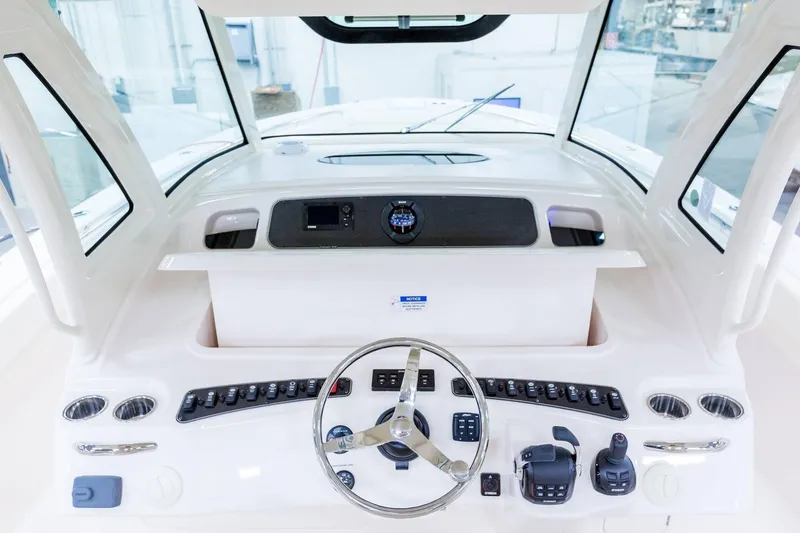 Slide: The Image of 2024 Grady-White Canyon 386 helm station with steering wheel and control panel. - 6