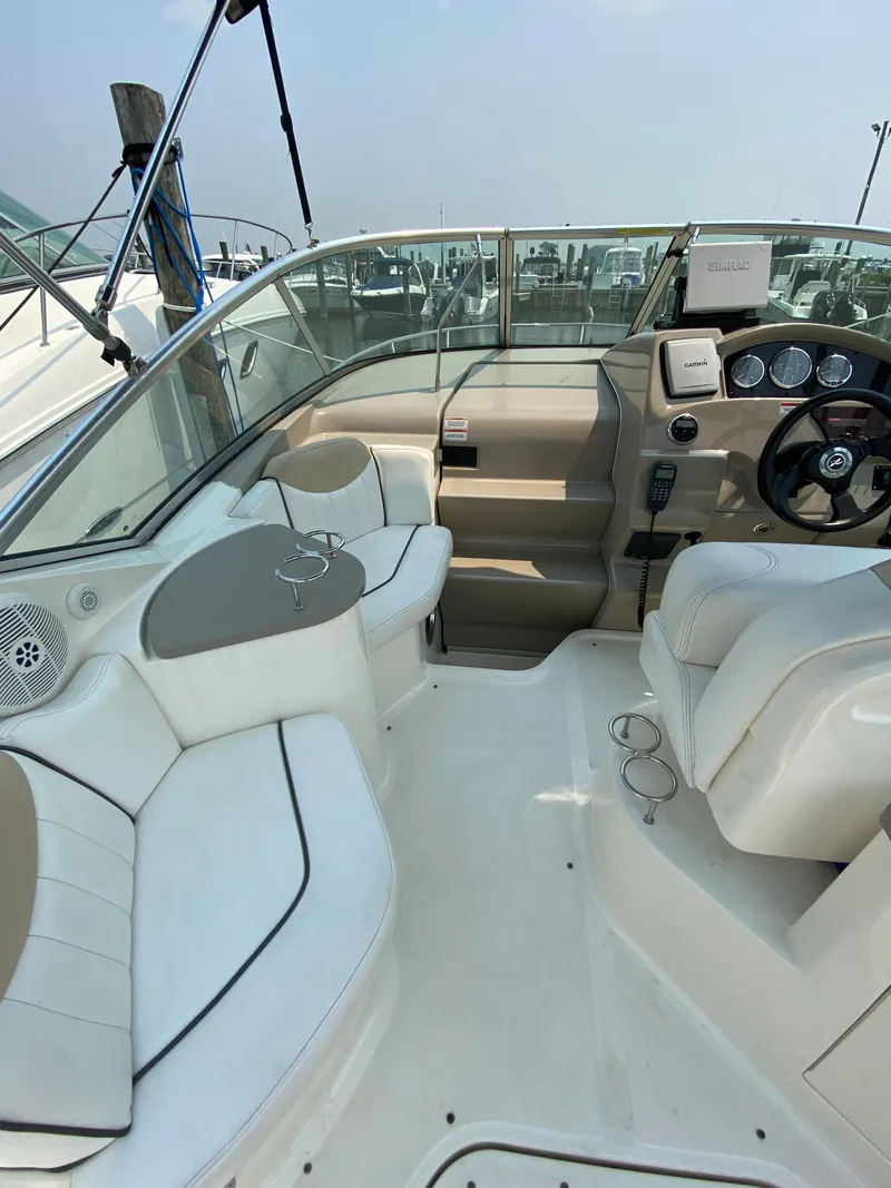 Slide: The Image of 2008 Sea Ray 240 Sundancer boat interior with white seating and steering console. - 11