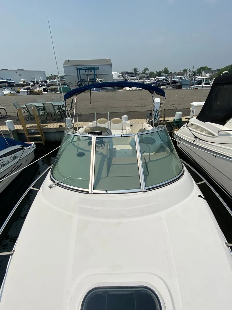 Slide: The Image of 2008 Sea Ray 240 Sundancer docked at marina, showcasing sleek design and spacious deck. - 15